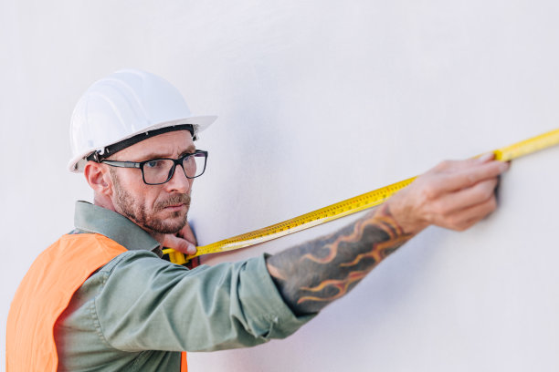 建筑工人，工程师，男性，专业，工作，测量墙壁，使用米尺，高细节精度图片下载