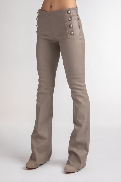 这位女士穿着黑色皮裤，只露出双腿。孤立的背景。侧角。图片下载