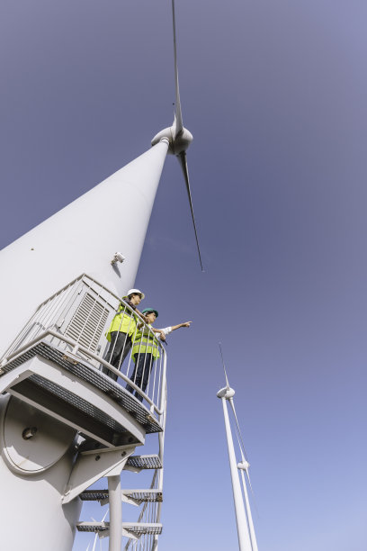 女工程师在风电场的风力涡轮机工作图片下载