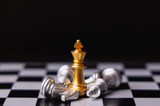 金王棋站在中央，周围是倒下的银王棋，骑士和其他棋子在黑色背景。商业竞争、营销策略和领导理念的赢家。图片下载