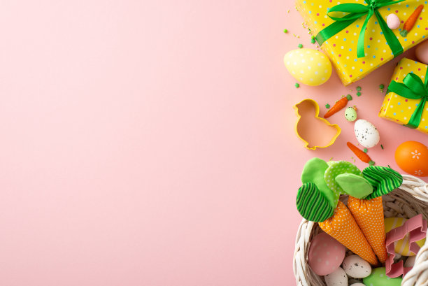 复活节的概念。顶部视图照片黄色礼盒与绿色蝴蝶结篮子复活节鸡蛋胡萝卜鸡形烘焙模具和撒在孤立的粉彩粉红色背景与空白图片下载