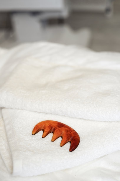 在水疗沙龙里，白毛巾上的瓜沙刮刀。副本的空间。图片下载