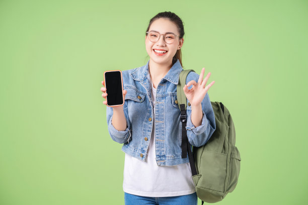 年轻的亚洲大学女孩的照片在绿色背景图片下载