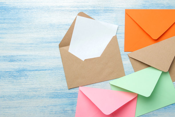蓝色的木桌上摆着五颜六色的信封，上面有空白的文字。俯视图图片下载