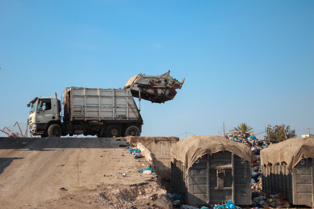 垃圾填埋场上的垃圾车图片下载