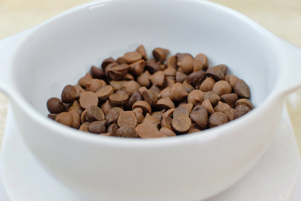 巧克力片放在白色的碗里。测量蛋糕配料图片下载