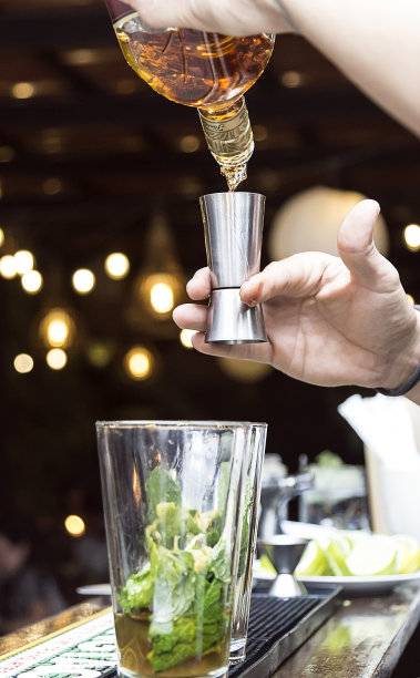 调酒师用鸡尾酒供应酒精。在夜间准备鸡尾酒。它可以是酒店、餐厅或夜总会。图片下载