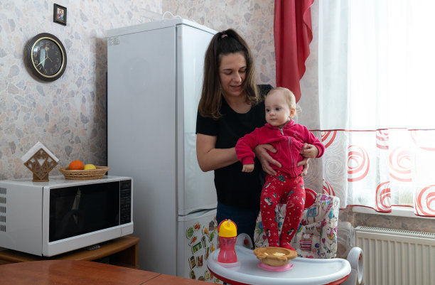 喂完饭，母亲把女儿抱在怀里。图片下载