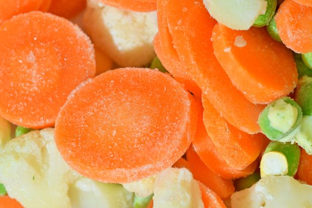 特写的冷冻汤蔬菜与胡萝卜，豌豆，花椰菜和玉米。冷冻蔬菜汤的口感。冷冻蔬菜汤的微距图像。平面设计，俯视图。水平的形象图片下载