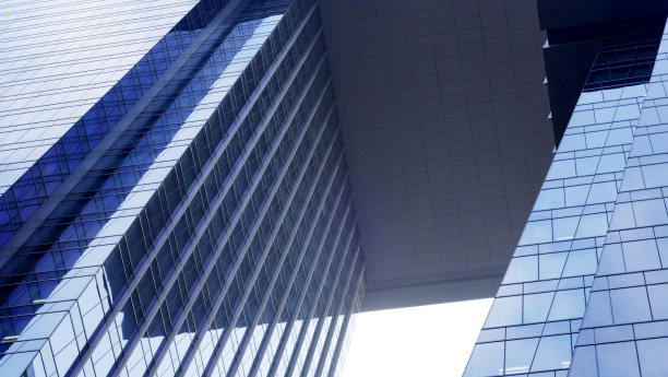 蓝色天空背景上的现代玻璃建筑特写。复制布局空间。图片下载