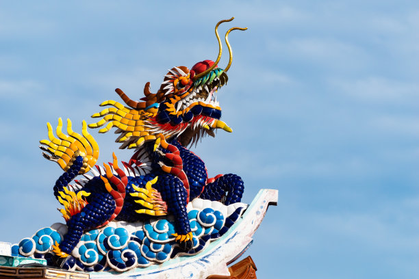 蓝色天空下，神社红色柱子上的金色神龙雕像图片下载
