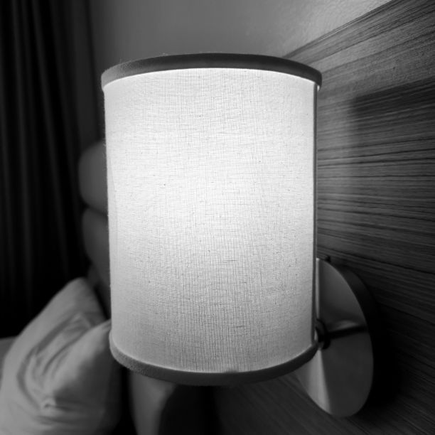 单色镜头的织物灯罩点燃在卧室的床旁边图片下载