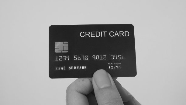 手握黑色信用卡孤立在白色背景。图片下载