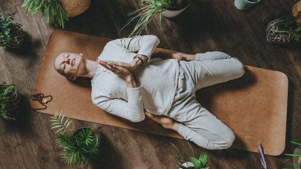 顶视图的年轻冥想男子躺在软木垫在Supta Virasana图片下载