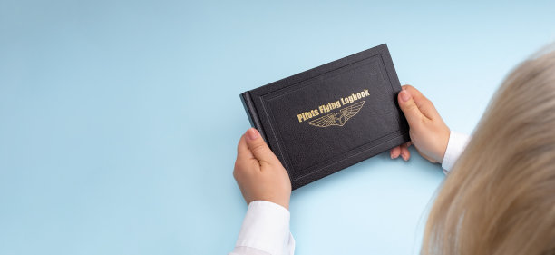 女子手里拿着一本飞行杂志，这是航空公司女飞行员的概念图片下载