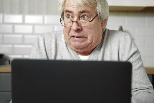 高级白发男子戴眼镜坐在笔记本电脑和鱼的脸与嘴唇。疯狂而滑稽的手势。滑稽的老爷爷带着俏皮的傻表情，做着鬼脸在鬼混图片下载