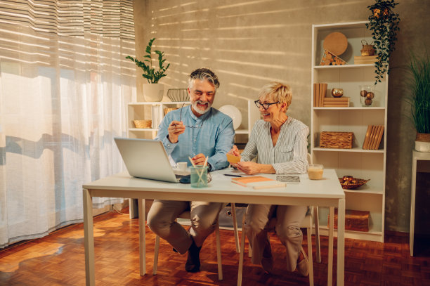 一对老年夫妇在家用信用卡和笔记本电脑网购图片下载