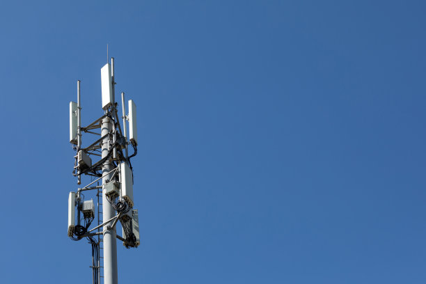 有4G、5G发射机的电信塔。在蓝天的映衬下，电信塔上带有发射天线的蜂窝基站图片下载