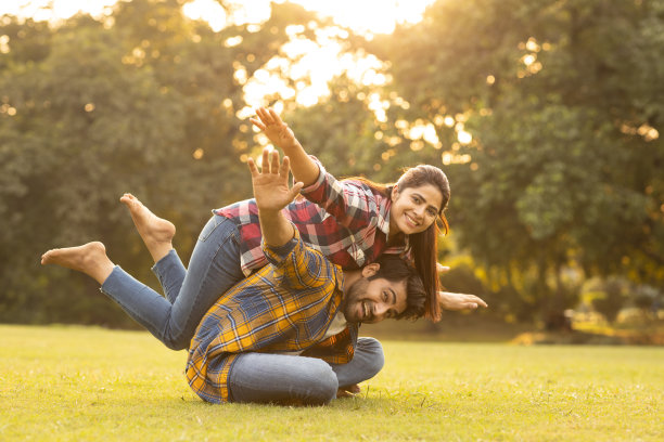 年轻夫妇在公园玩得很开心。库存图片图片下载