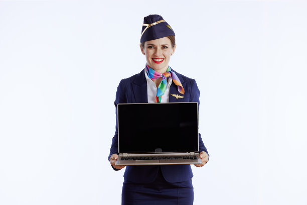 女空姐微笑着展示笔记本电脑的空白屏幕图片下载