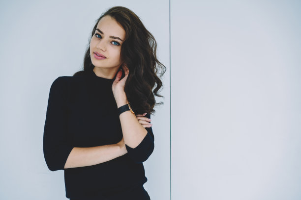 自信的年轻女子站在白色背景下看着相机图片下载