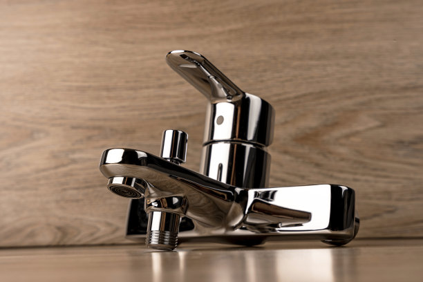 瓷砖背景上的新闪亮水槽水龙头图片下载