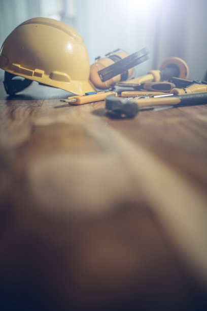 木桌上有建筑工具和一顶黄色头盔图片下载