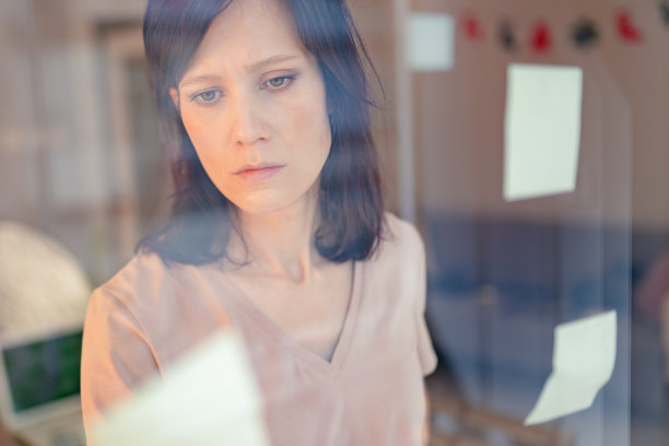 一名妇女正在用贴纸贴在玻璃窗上图片下载