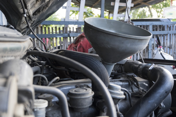 汽车机械师改变和注入新鲜的油到发动机-库存照片图片下载