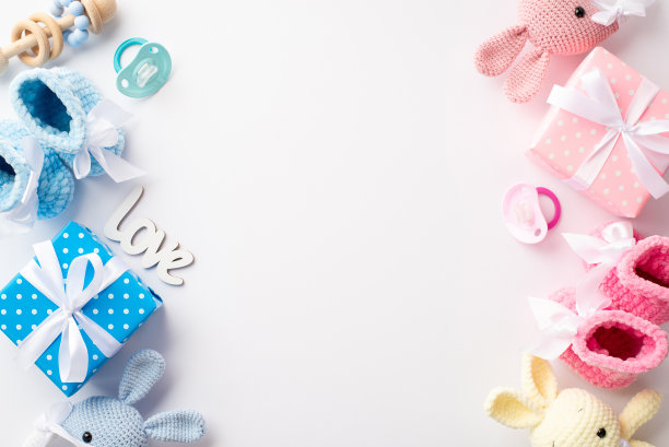 性别揭示党的概念。粉红色和蓝色礼盒针织靴子兔拨浪鼓玩具铭文爱和安抚奶嘴在孤立的白色背景与中间空白的顶部视图照片图片下载