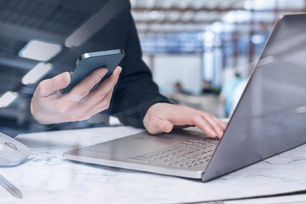 商人同时在手机和笔记本电脑上工作。图片下载