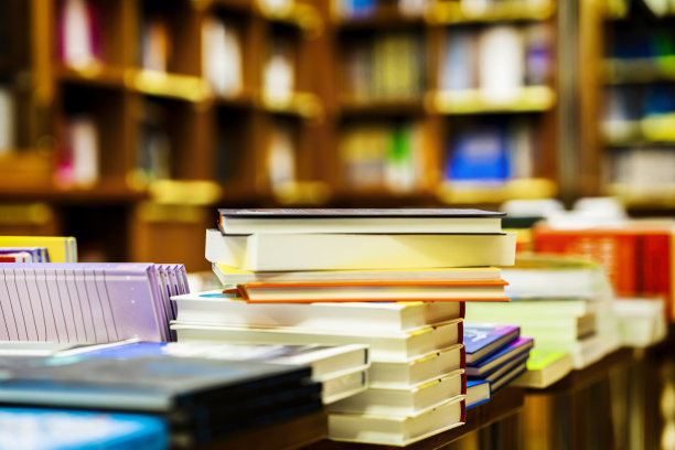 模糊的书店与书在桌子和书架上。教育，学校，学习，阅读小说概念图片下载