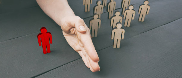 女人的手把一个木人和另一组木人分开。人与人之间的距离观念，预防疾病和病毒。呆在家里图片下载