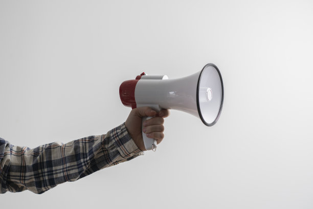 在单色背景下，手拿扬声器或扩音器图片下载