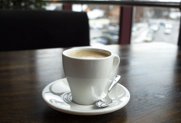 咖啡馆的木桌上有一杯白色的拿铁咖啡图片下载