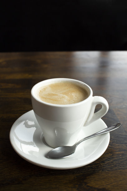 咖啡馆的木桌上有一杯白色的拿铁咖啡图片下载