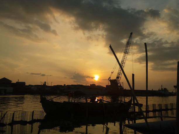 夕阳下船只和起重机的剪影。港口的日落图片下载