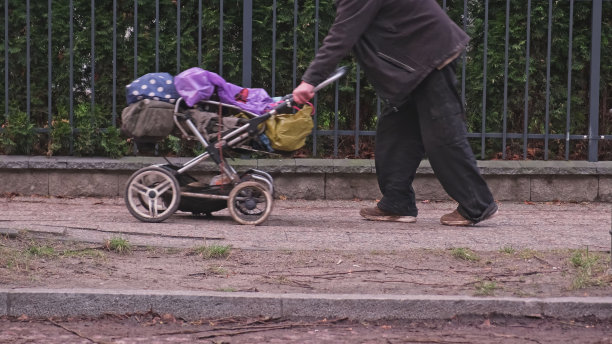 无家可归的人推着装满个人物品的婴儿车图片下载