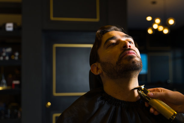 英俊的男子在理发店刮胡子图片下载