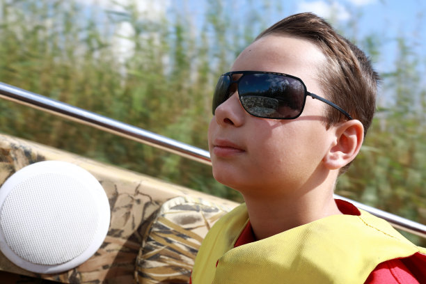 男孩在摩托艇通过河口图片下载