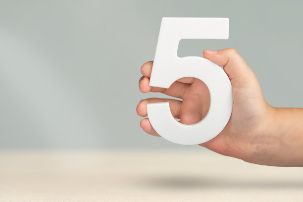 5号在手上。手握白色数字5在模糊的背景与复制空间。第五个概念。生日5岁，五年级，每周工作五天图片下载