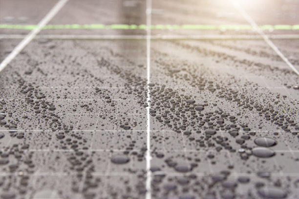 绿色能源。太阳能电池板与雨滴接近。在恶劣环境中使用防水太阳能电池板，生产绿色能源。图片下载