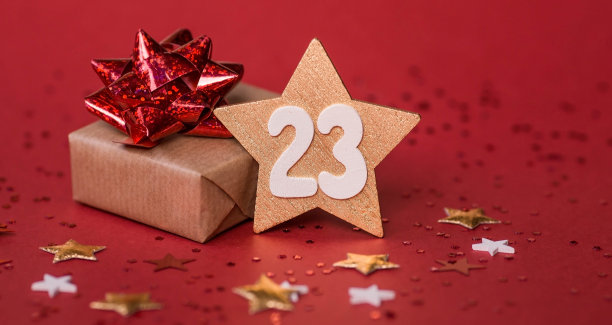 给祖国保卫者节的贺卡。白色，金色，红色星星，礼盒和红色背景上的数字23。假期是2月23日。图片下载