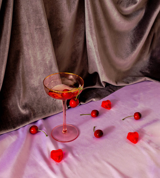 香槟酒杯、樱桃和爱心装饰，粉色织物和米色背景，生日贺卡或母亲节庆祝banner的简约奢华概念图片下载