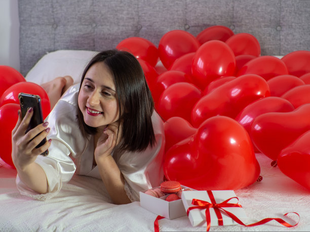 情人节派对上，一名女子躺在气球装饰中图片下载