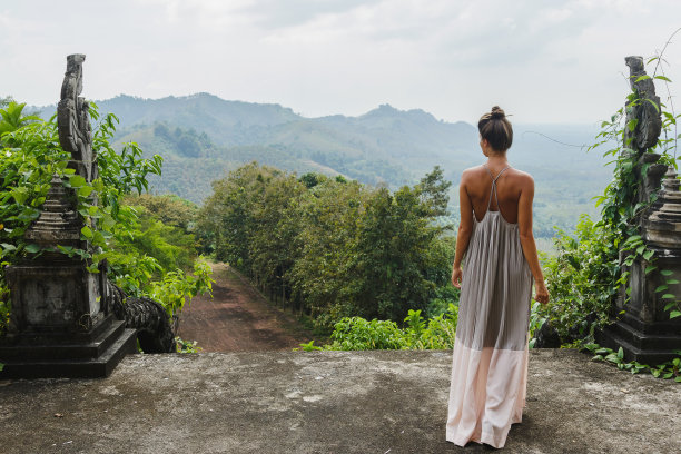 一个女人站在一个古老的亚洲宫殿的废墟中，穿着一件美丽的长裙图片下载