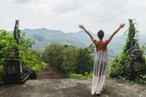 一个女人站在一个古老的亚洲宫殿的废墟中，穿着一件美丽的长裙图片下载