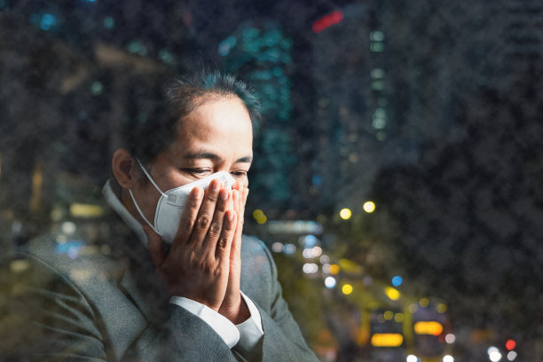 女性佩戴N95 PM 2.5呼吸防护口罩，防止空气污染和粉尘颗粒超过安全限度。健康、环保、生态理念。过敏、头痛。城市空气危险。图片下载