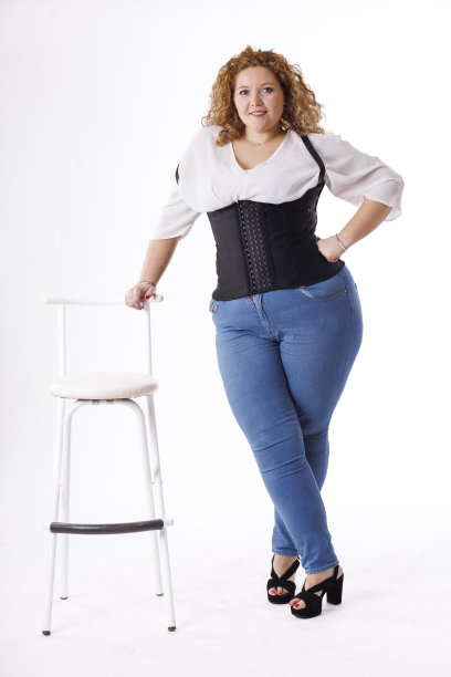 加码时装模特，牛仔衣服和白衬衫在白底，超重的女性身体图片下载