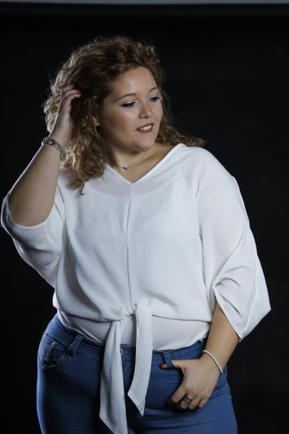 加码时装模特牛仔衣服和白衬衫在黑色背景，超重的女性身体图片下载